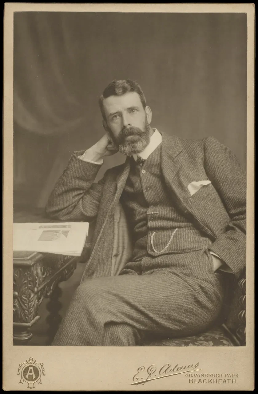 Black and white photograph of Henry Outhwaite. He is seated, his head leaning on his arm against the table.