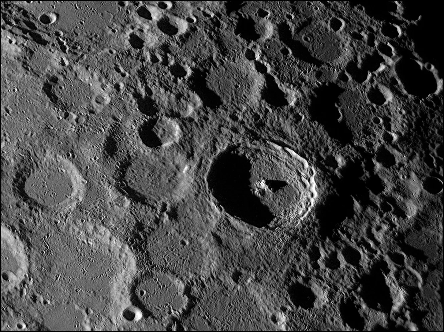 A black and white photograph of a lunar crater, showing lots of circular shapes of different sizes and depths