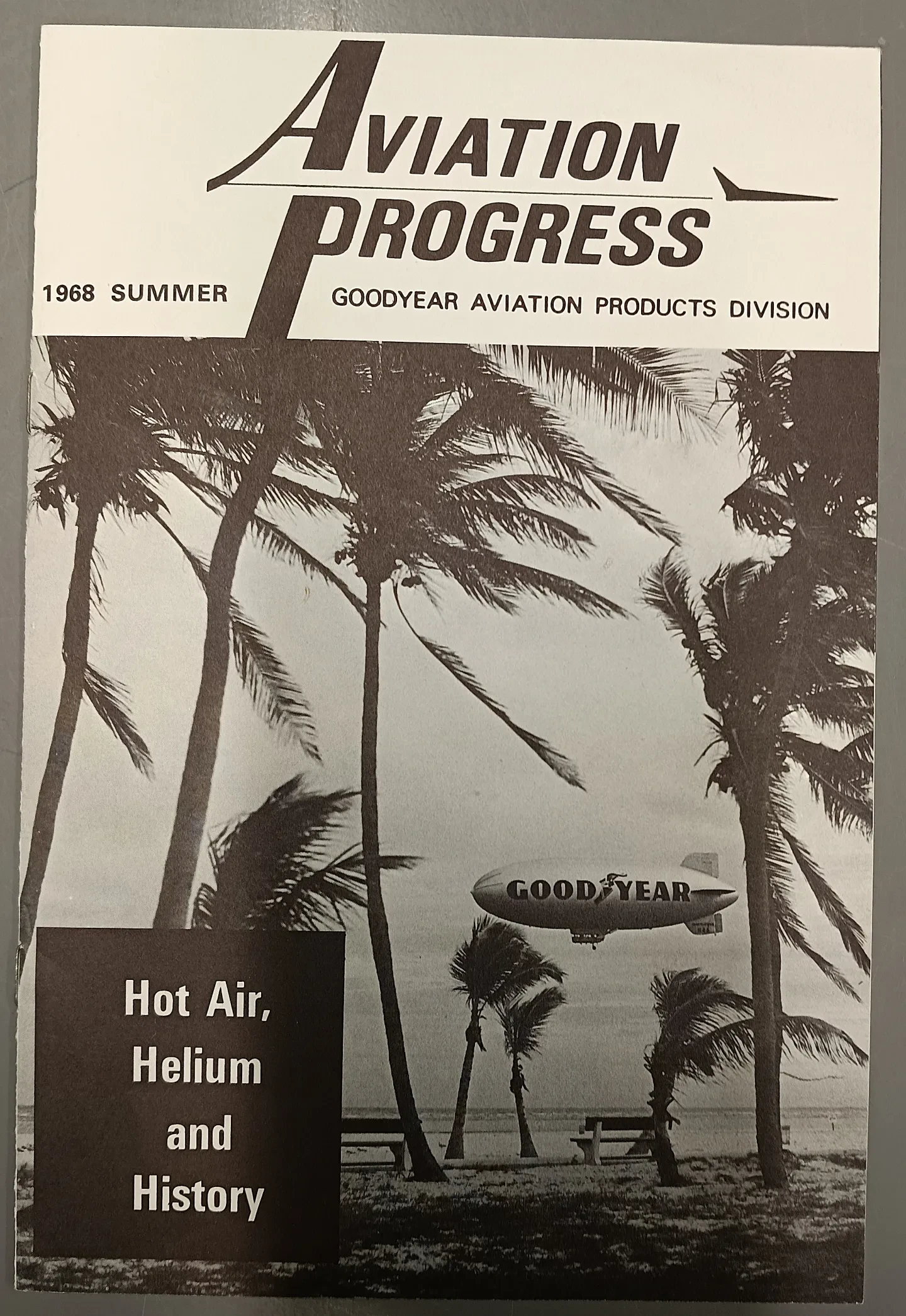 A photo of a 1968 Goodyear brochure. It features palm trees with a blimp with the word goodyear on it in the distance