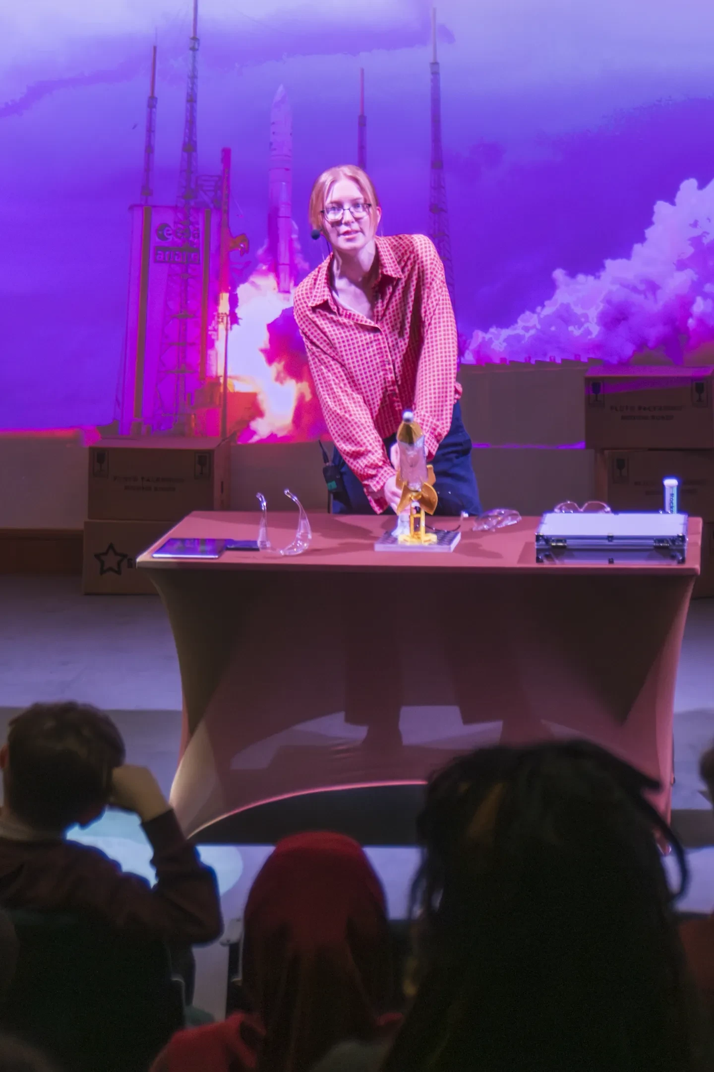 Presenter on stage holding a small model rocket