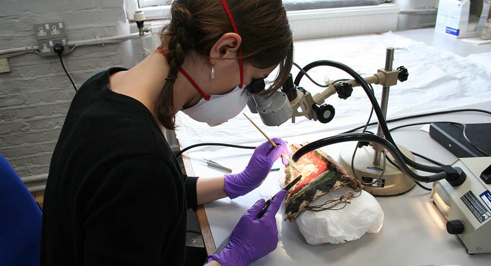 Conservator working on the ethnographic mask