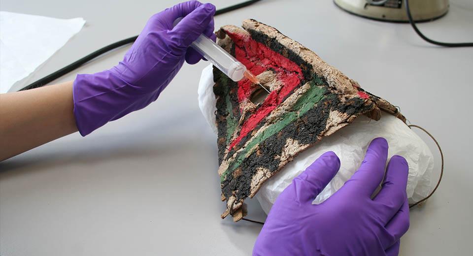 Conservator working on the ethnographic mask