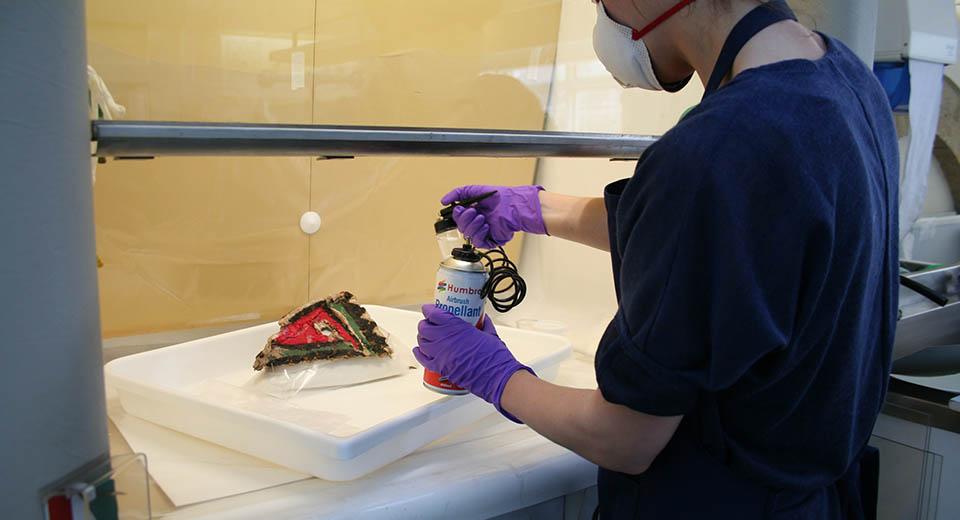 Conservator working on the ethnographic mask