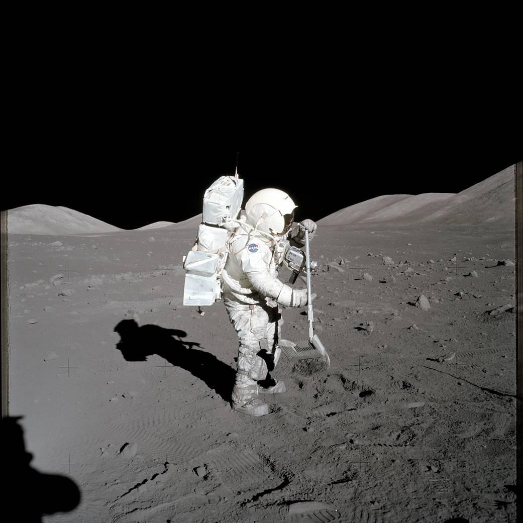 Harrison H. Schmitt in a space suit collecting lunar rake samples.