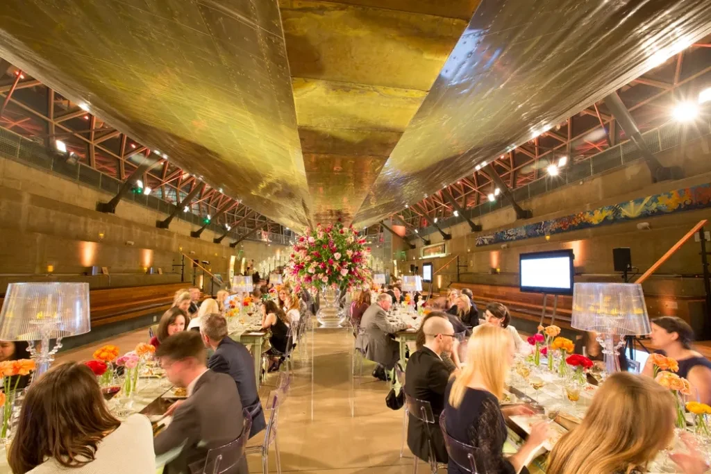 Diners at long dressed tables under the hull of Cutty Sark.