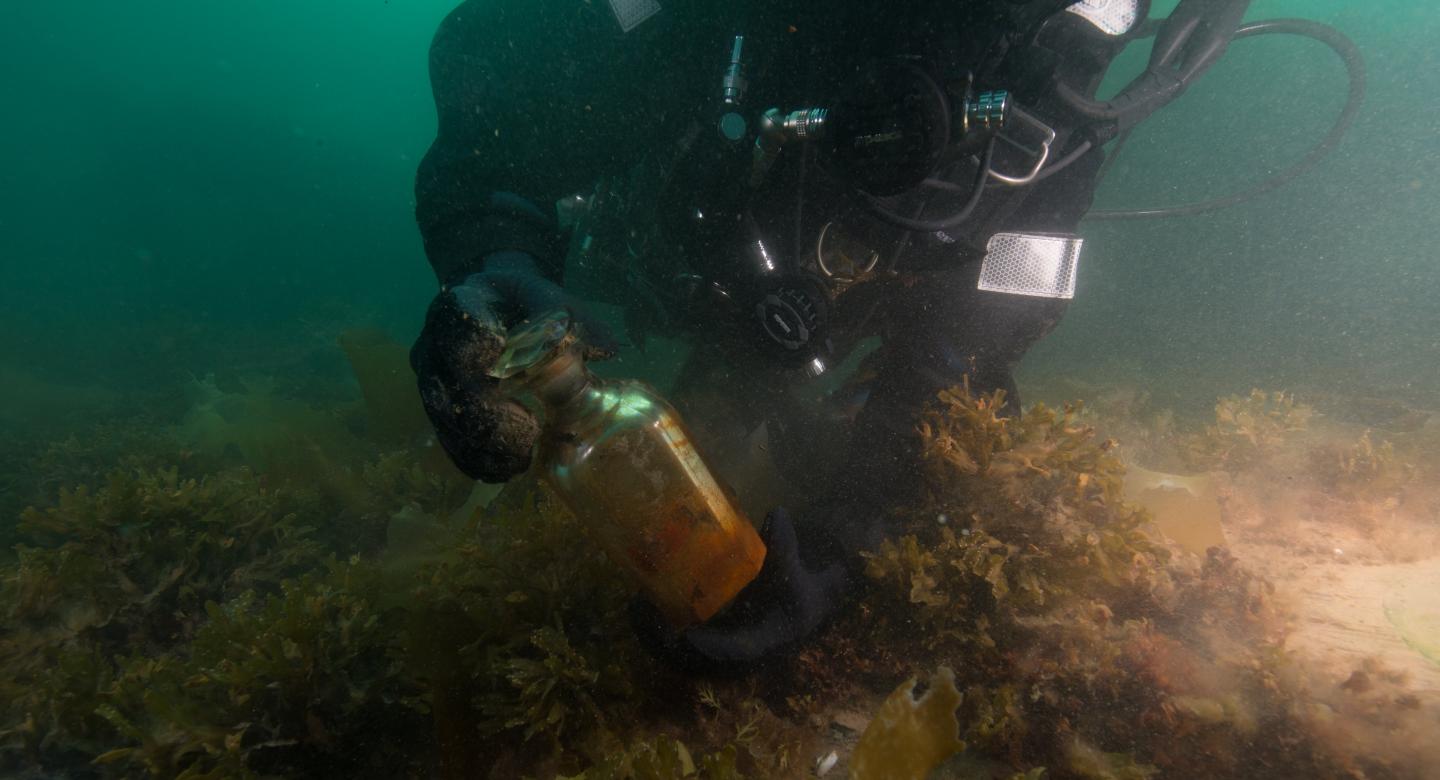 A diver recovers a decanter from the wreck of HMS Erebus (© Parks Canada)