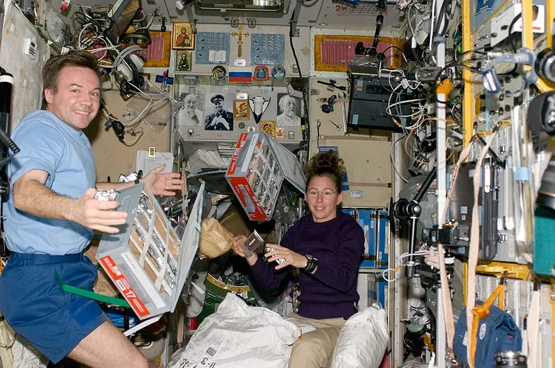 Sandra Magnus and Yuri Lonchakov with food storage containers in the Zvezda Service Module
