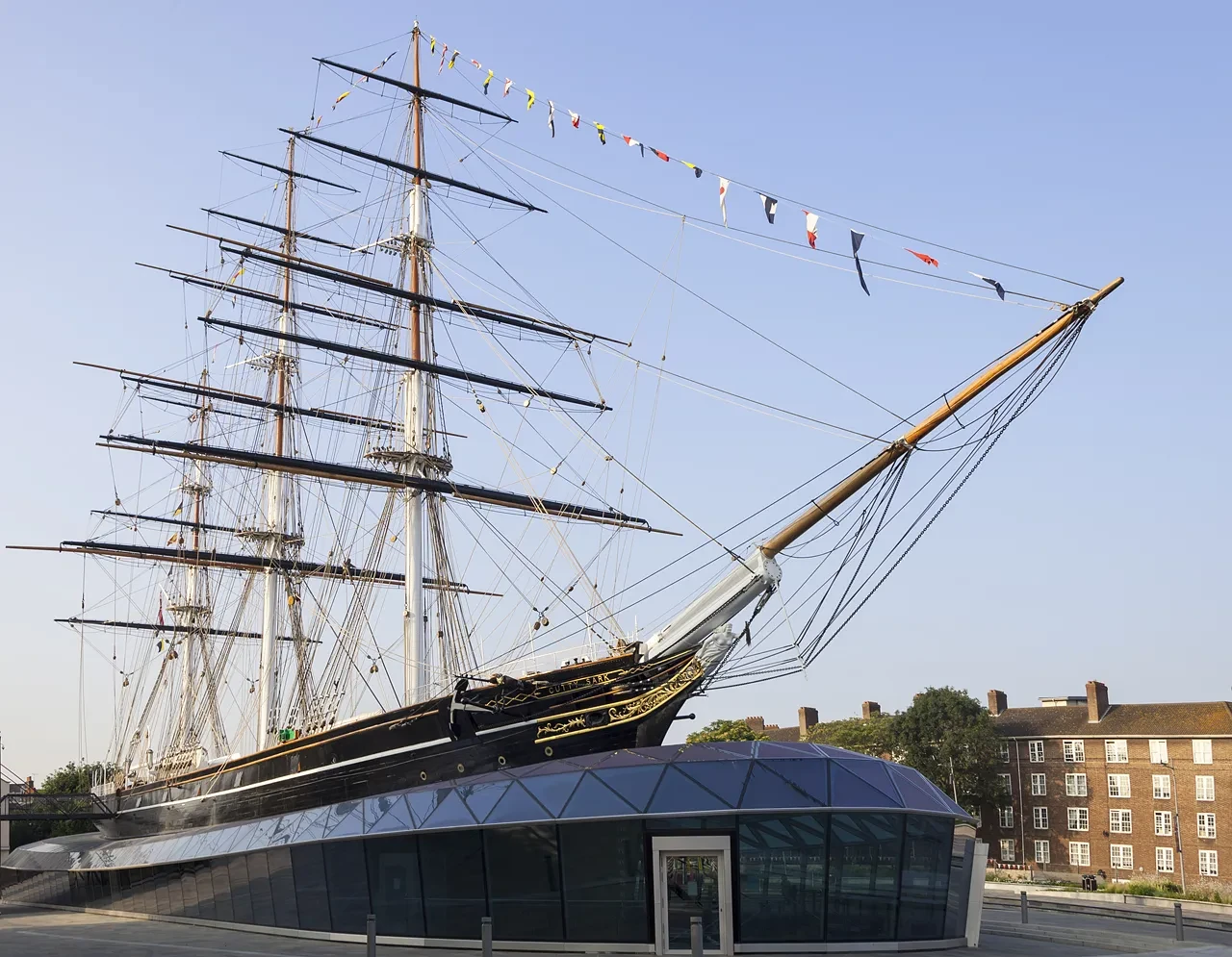 The dry-docked ship Cutty Sark against a blue sky.