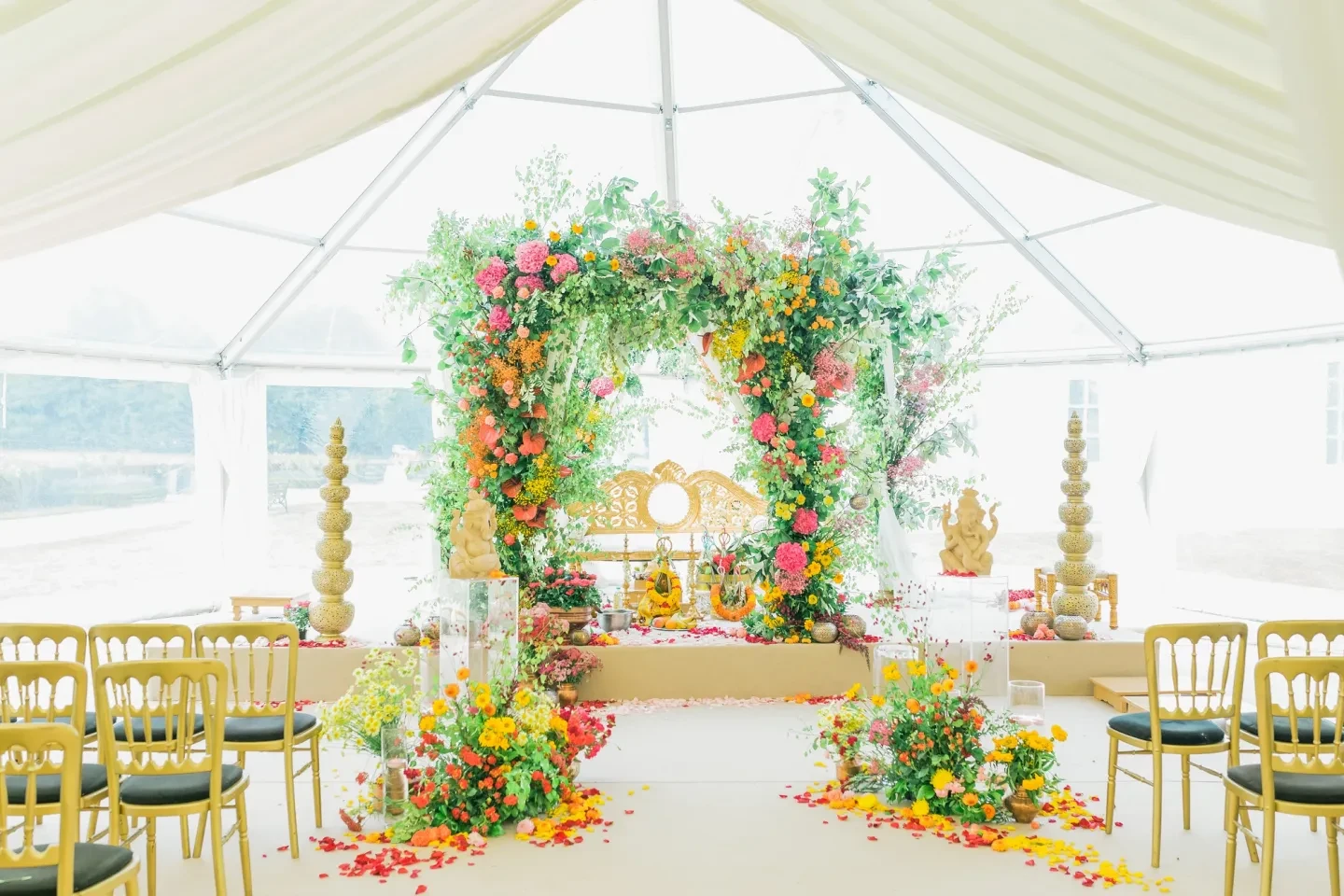 A wedding ceremony setup with a floral arch at the end of the aisle.