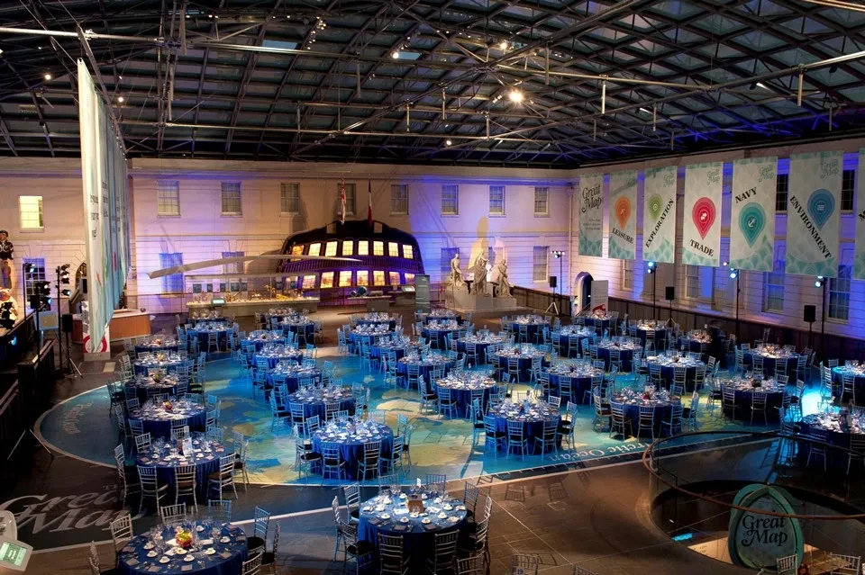 Tables ready for an event in Ocean Court at night, with blue lighting.