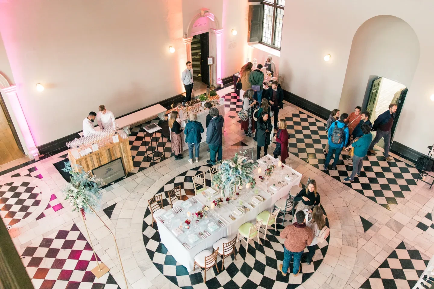 A view from above of an event in progress on a black and white tiled floor.