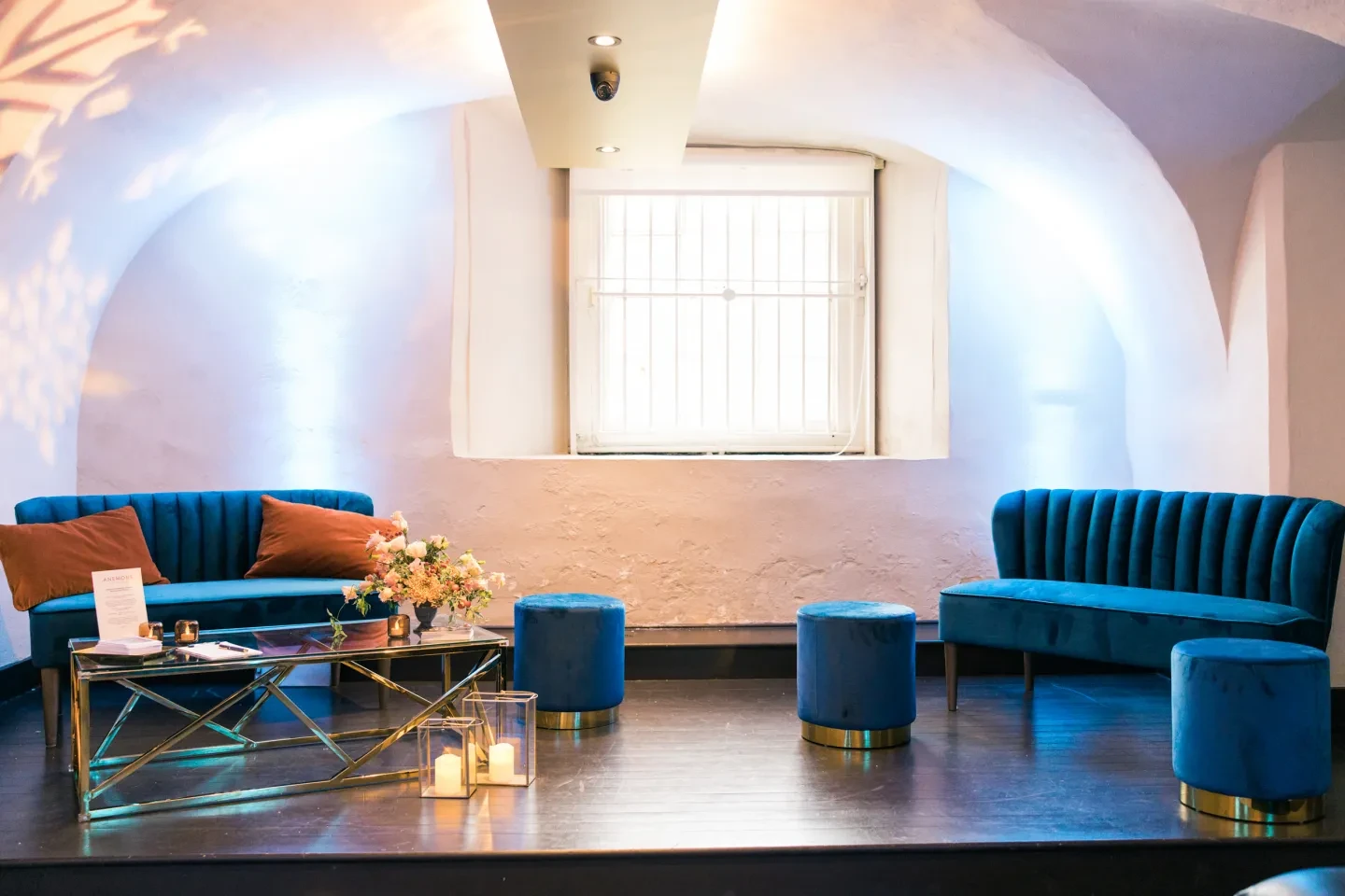 Plush blue and gold furniture in a white room.