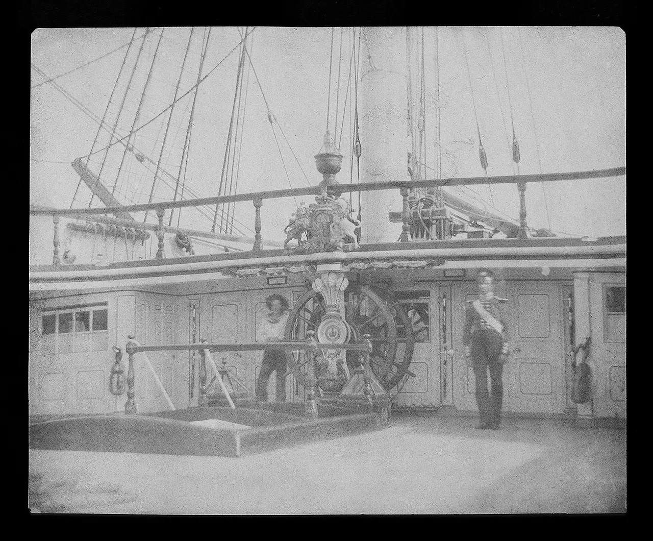 A negative image showing sailors on the deck of a ship.