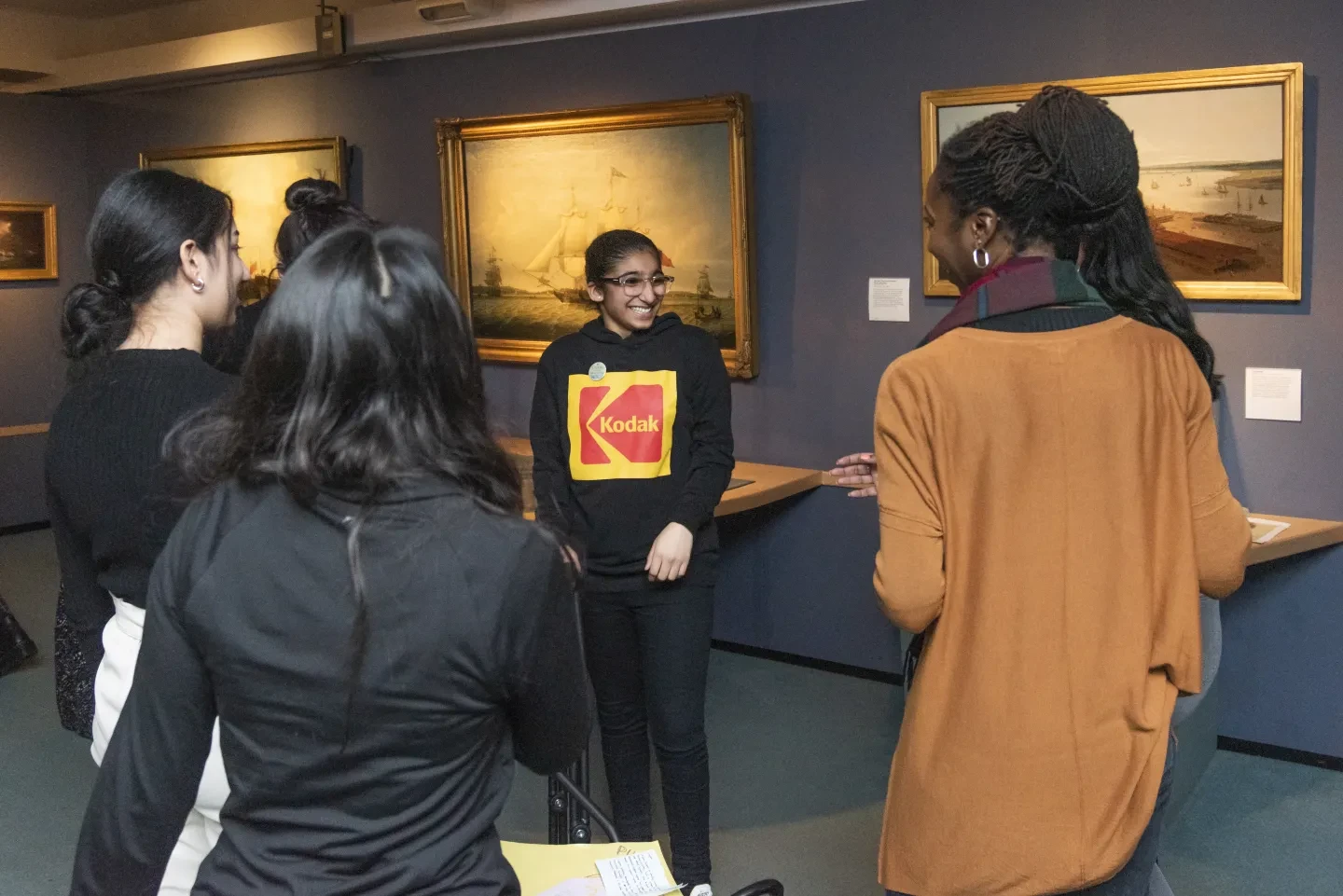 A group of young people chatting in an art gallery.