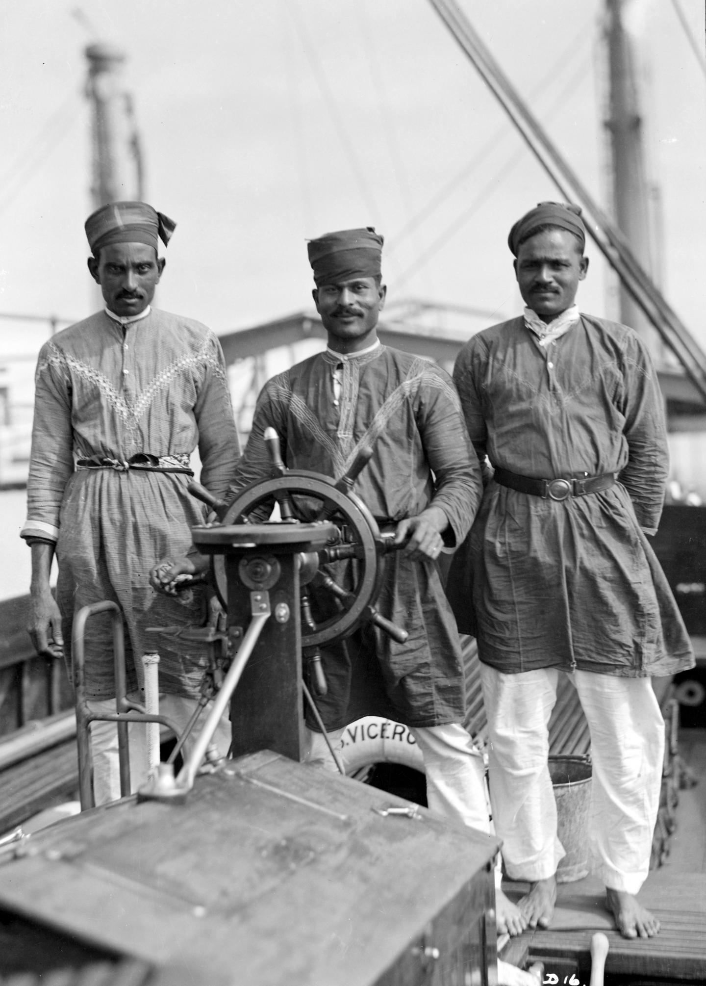 Three Lascars of the 'Viceroy of India' (1929), standing behind the wheel of one of the ship's tenders by Marine Photo Service (Waterline Collection) circa 1935