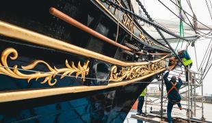 Shipkeepers work to reattach the figurehead to historic ship Cutty Sark