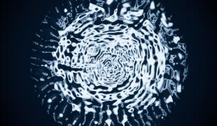 Image of blue circle of water forming a unique pattern of droplets against a black background