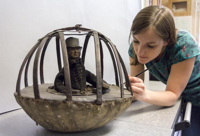 A museum conservator examines an object from the collection at Royal Museums Greenwich