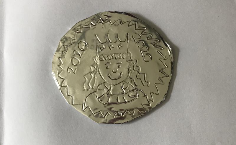 Circular foil medal with drawn on person with a crown and decorative marks