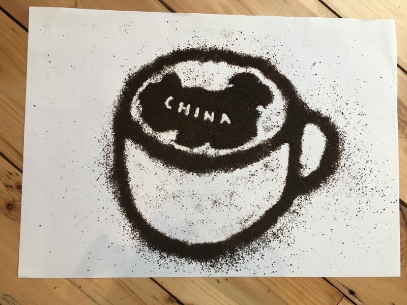A spice drawing of a mug made with black tea grains which show an image of china in the cup