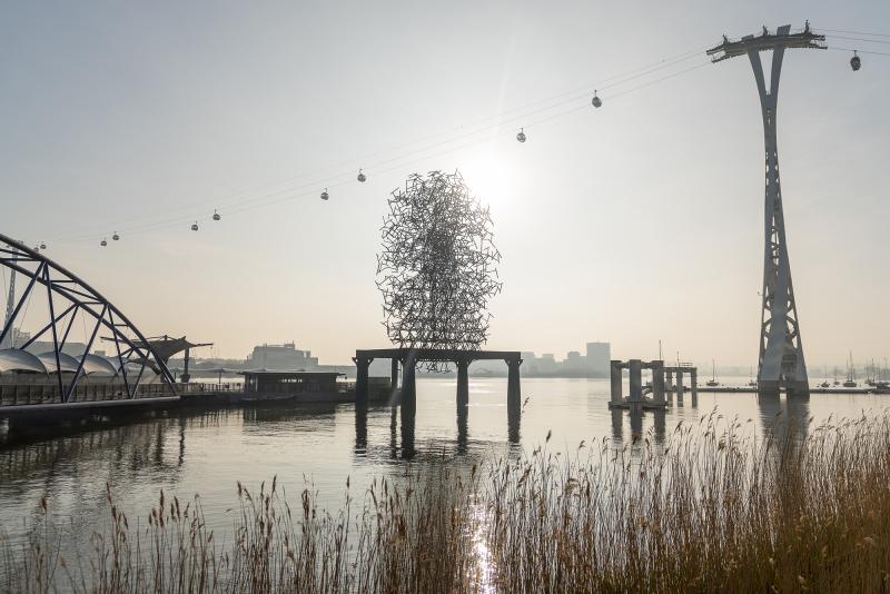 A photo of Antony Gormley sculpture Quantum Cloud at sunrise. The sculpture sits on a platform in the River Thames