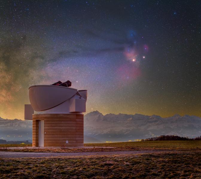 A small observatory points up towards a purple sky, studded with stars