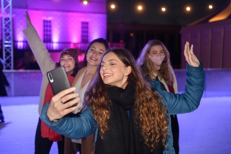 A group of young women take a selfie at the Queen's House Ice Rink