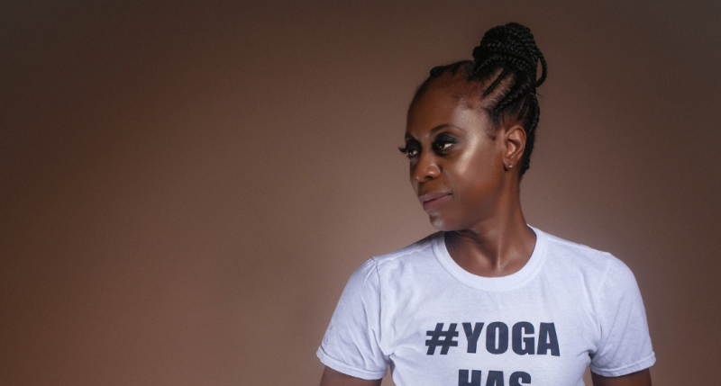 Woman wearing white t-shirt which says #Yoga has no size