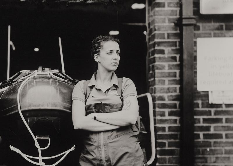 Black and white portrait of a woman leaning against a boat