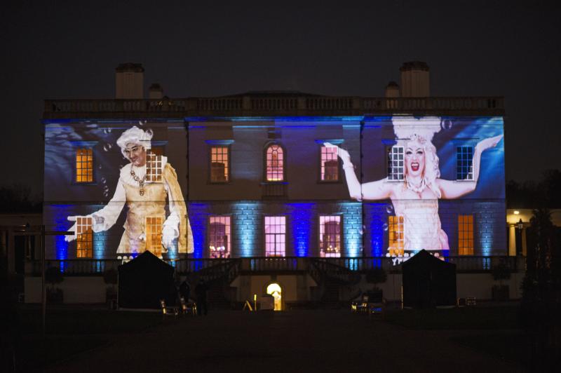 A photo of Adam All and Apple Derrieres in royal attire projected onto the front of the Queen's House as part of the Fierce Queens event to celebrate LGBTQ+ History Month